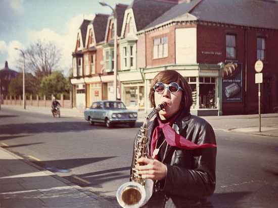 John, colorfully dressed, playing a sax on the street in Hull, 1969