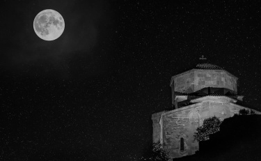 Full moon over
                a monastery building