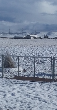 John's low gate,
                surrounded by snow, with ominous clouds over the distant
                mountains